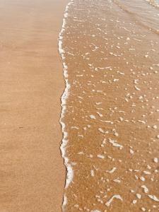 a close up of the sand and water on the beach at Hôtel L'Albatros in Saint-Trojan-les-Bains