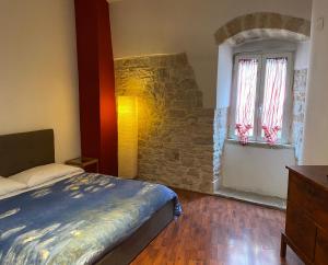 a bedroom with a bed and a stone wall at Pikaret Bed&Breakfast in Corato
