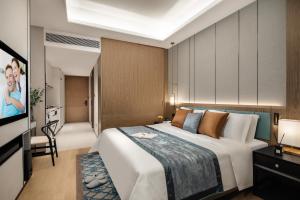 a bedroom with a large bed and a television at Ascott M-City Foshan in Foshan