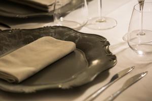 a plate with a napkin on a table with wine glasses at Mediterraneo Emotional Hotel & Spa in Santa Margherita Ligure