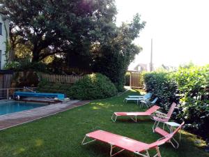 a yard with two lawn chairs and a pool at Apartamento Tipo Loft in Somo