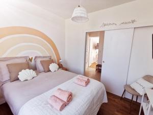 a bedroom with a large bed with pink towels on it at Les Rauches - Quai Loire - Suite 2 Chambres in Châteauneuf-sur-Loire