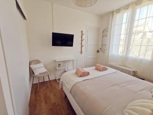 a white bedroom with a bed and a chair at Les Rauches - Quai Loire - Suite 2 Chambres in Châteauneuf-sur-Loire