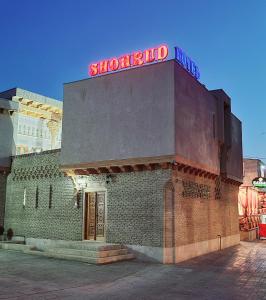 a brick building with a sign on top of it at Hotel SHOHRUD in Bukhara