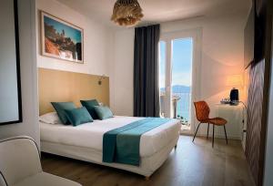 a bedroom with a bed and a large window at Hotel l'Isolella in Porticcio