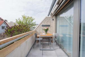 uma varanda com uma mesa com flores em Haus Harmening Whg 4 em Norderney