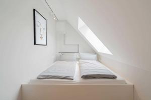 uma cama num quarto branco com uma escada em Haus Harmening Whg 4 em Norderney