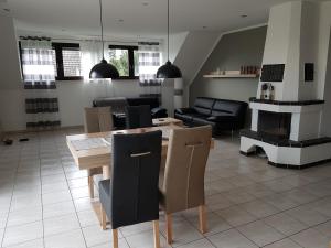 a living room with a table and a fireplace at FewoSa Trier-Tarforst in Trier