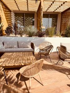 a patio with a couch and chairs and a table at Hôtel L'Albatros in Saint-Trojan-les-Bains