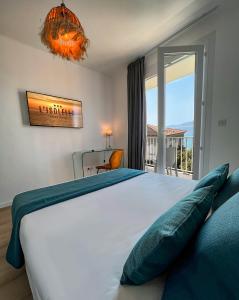a bedroom with a large bed and a balcony at Hotel l'Isolella in Porticcio