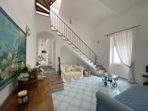 a living room with a staircase and a couch at Regina di Capri - Sopramonte - in Capri