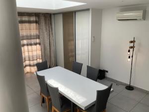 a dining room with a white table and chairs at VILLA OCEANE in San-Nicolao +3 photos