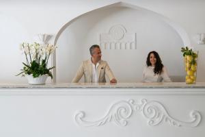 a man and a woman standing in front of a mirror at La Residenza Capri in Capri