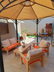 een patio met banken en een grote parasol bij רקפת - יחידה במדבר in Arad