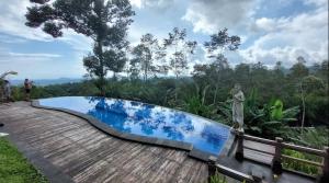 - une piscine sur une terrasse en bois dans l'établissement Umah Legenda Bali - Legend House Bali, à Tabanan