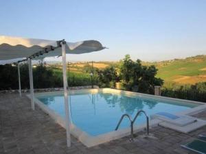 duży basen z parasolem i anophe w obiekcie Exclusive Swimming Pool w mieście Miglianico