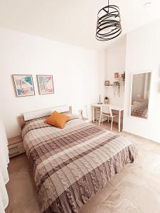 a white bedroom with a large bed and a desk at רקפת - יחידה במדבר in Arad