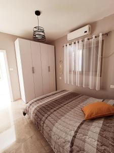 Un dormitorio con una cama grande y una ventana en רקפת - יחידה במדבר en Arad