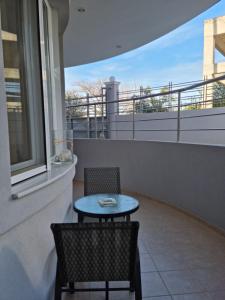 a small table and two chairs on a balcony at LiriKa's airport house in Artemida