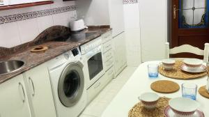 a kitchen with a washing machine and a table at Sopelana pueblo con Garaje & Wifi in Sopelana
