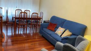 een woonkamer met een blauwe bank en een tafel bij Sopelana pueblo con Garaje & Wifi in Sopelana