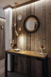 a table with two wine glasses and a mirror at The Grey Lodge at Bosco Verde in San Cassiano