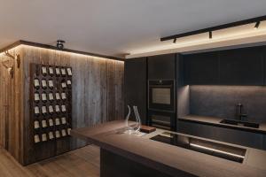 cocina con barra y estante para vinos en The Grey Lodge at Bosco Verde, en San Cassiano