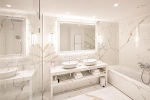 a bathroom with two sinks and a tub and a mirror at De Tuilerieën - Small Luxury Hotels of the World in Bruges +94 photos