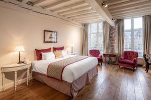
a hotel room with a bed and a chair at De Tuilerieën - Small Luxury Hotels of the World in Bruges
