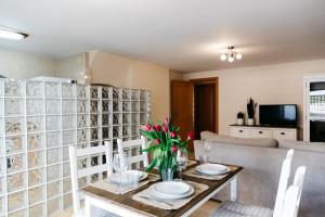 uma sala de jantar com uma mesa com pratos e flores em Townhouse with terraces and communal pool em Gandia