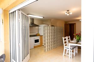 a kitchen with a refrigerator and a table and chairs at Townhouse with terraces and communal pool in Gandía
