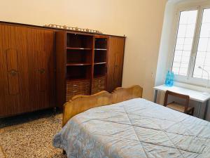 a bedroom with a bed and a wooden cabinet at MH Genova in Genoa
