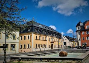 um grande edifício com um telhado preto numa rua em Hotel Brander Hof em Brand-Erbisdorf