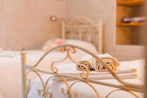 ein Bett mit weißer Bettwäsche und Handtüchern darauf in der Unterkunft La Casetta Antica in Noci