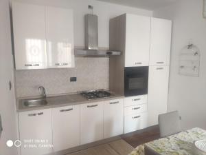 a kitchen with white cabinets and a sink and a stove at Appartamento Santacroce in Pratola Peligna