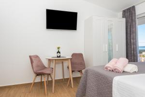 a bedroom with a bed and two chairs and a table at Milka Apartments in Makarska