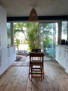 a kitchen with a wooden table and a wooden floor at Centre & plage - T2 cosy avec terrasse & jardin in Saint-Gilles les Bains