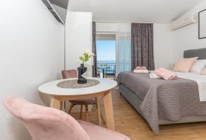 a bedroom with a bed and a table and chairs at Milka Apartments in Makarska
