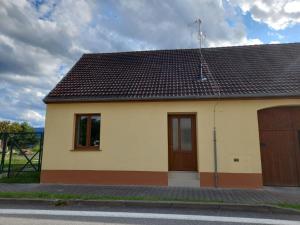 a small yellow house with a brown door at Penzion U strejčků in Veselí nad Lužnicí