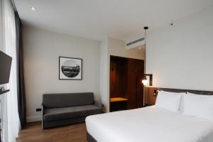 a hotel room with a bed and a chair at Holiday Inn Telavi, an IHG Hotel in Tʼelavi