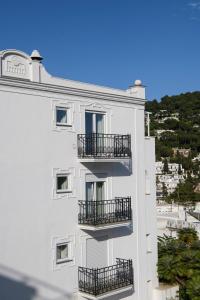 a white building with balconies on the side of it at La Residenza Capri in Capri