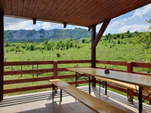 um alpendre com uma mesa de piquenique e vista para as montanhas em Réteskert vendégház és apartman em Bélapátfalva