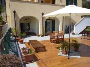 a patio with tables and chairs and an umbrella at Casa Papaveri Rossi in Finale Ligure