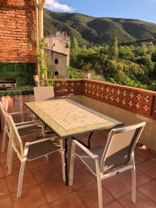 een tafel en stoelen op een balkon met uitzicht bij Le Kerrete in Céret