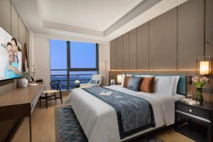 a hotel room with a large bed and a television at Ascott M-City Foshan in Foshan