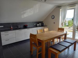 a kitchen with a wooden table and chairs at Ferienwohnung Schwarzwald-Baar Blick in Donaueschingen