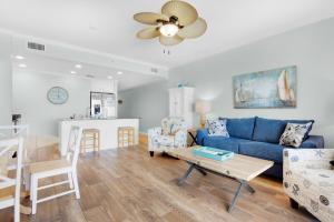 a living room with a blue couch and a table at Sterling Reef 102 in Panama City Beach