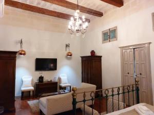 ein Wohnzimmer mit einem TV und einem Kronleuchter in der Unterkunft Casa Birmula Boutique Hotel in Cospicua