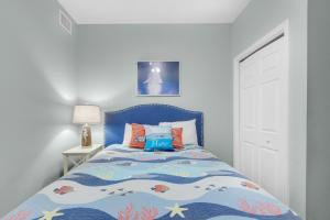 a bed with a blue headboard in a bedroom at Sterling Reef 102 in Panama City Beach +32 photos