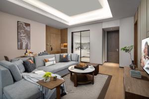 a living room with a couch and a table at Ascott M-City Foshan in Foshan
